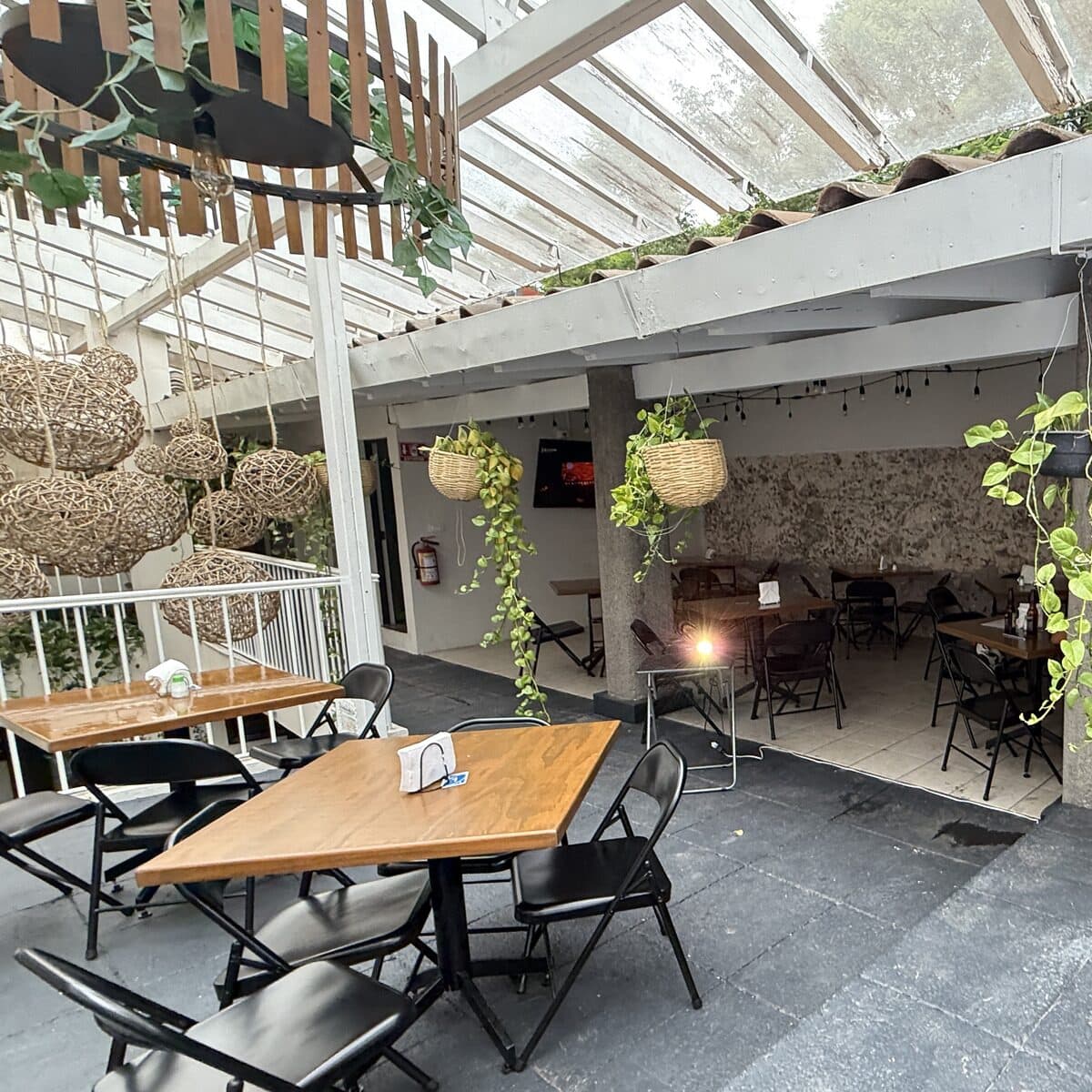 La terraza abierta, con el piso de piedra en primer plano y la barra al fondo
